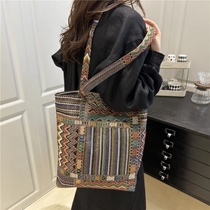 Bohemian style woven tote bag with colorful geometric patterns and thick shoulder strap