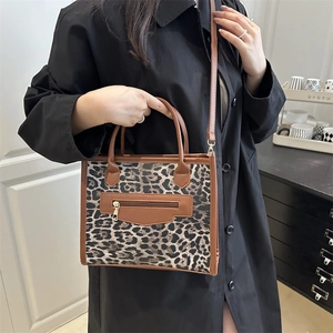 Leopard print canvas crossbody bag with brown leather trim and zip pocket on model
