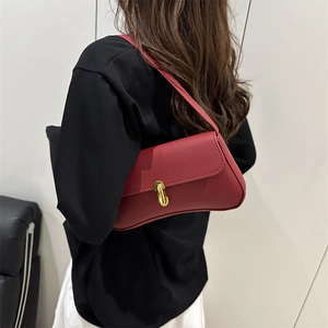 Deep red baguette shoulder bag in lychee leather featuring a gold J-shaped metal buckle