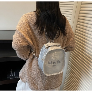 Silver metallic mini backpack with chain strap detail shown on model in stylish setting