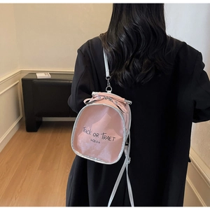 Pink mini backpack with silver piping and Trick or Treat text worn by a model