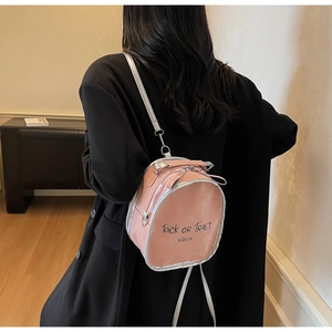 Rear view of a model wearing a pink mini backpack with Halloween lettering on a black coat