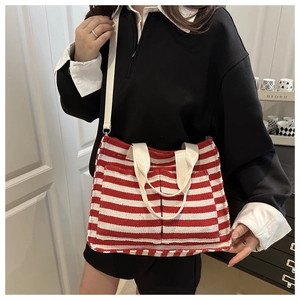 Detail of red and white striped tote bag with double front pockets and adjustable strap