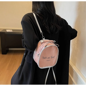 Detailed back view of model wearing pink backpack with silver trim and graphic text