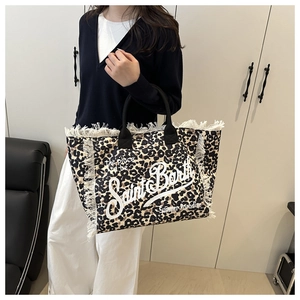 Detail of leopard print tote bag with white frayed fringe edges and black handles