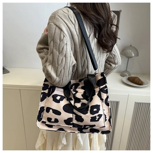Dettaglio della borsa tote leopardata con tasche funzionali e cinghie in tela nera