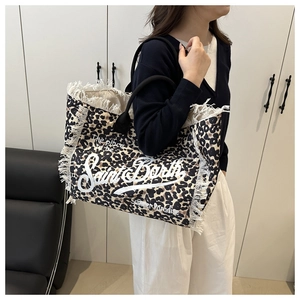 Leopard print tote bag with white fringe and Saint Barth text shown on shoulder