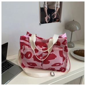 Dettaglio della borsa tote rosa con doppie tasche su una scrivania bianca pulita