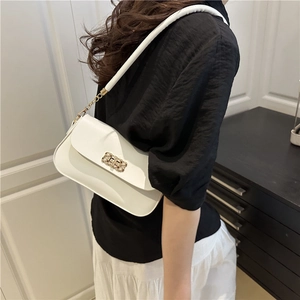 Sac bandoulière blanc minimaliste avec serrure dorée et bandoulière chaîne sur modèle