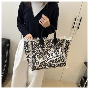 Macro detail of leopard print tote bag with white fringes and Saint Barth typography