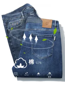 Detail of embroidered back pocket and leather brand patch on blue denim jeans