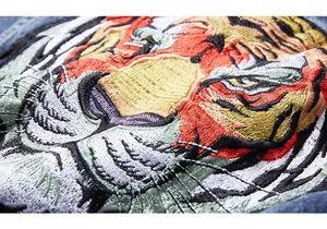 Gros plan détaillé d'une broderie de tigre haut de gamme sur un gilet en denim bleu