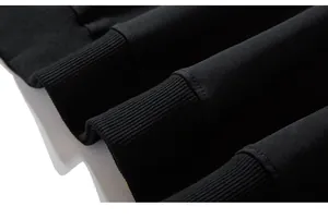 Detailed close-up of ribbed cuffs on a black oversized crewneck sweatshirt with fine stitching