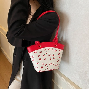 Chic white bucket bag with cherry print and red leather trim for fashionable women