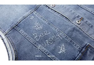 Macro detail of 'Bee Yourself' embroidery on vintage washed blue denim vest for men