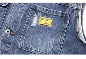 Détail de broderie lourde et poche poitrine usée sur le gilet en jean pour homme