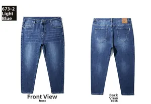 Detail of light blue straight-leg jeans featuring leather brand patch and back pocket stitching