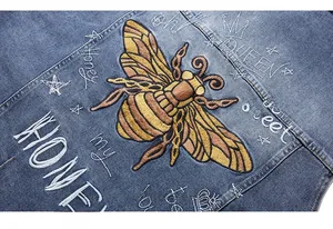 Detail of heavy embroidery bee and graffiti on blue denim jacket for men