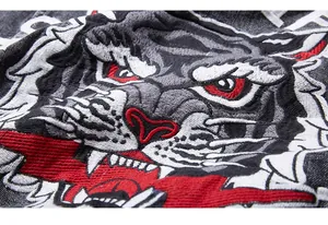 Detailed close-up of tiger head embroidery on high-quality dark denim jacket