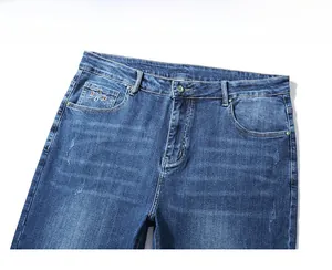 Detailed view of high-waisted dark blue denim jeans featuring BAD embroidery on pocket