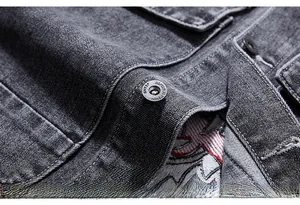 Detail of dark denim vest showing heavy embroidery and metal buttons with engraved logo