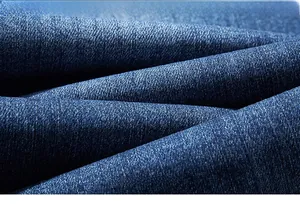 Detailed macro shot of deep blue denim fabric texture and diagonal twill weaving pattern