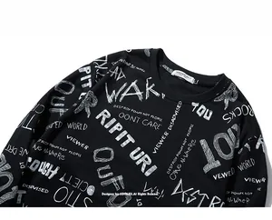 Detail of black crewneck sweatshirt featuring white street graffiti letters and cotton texture