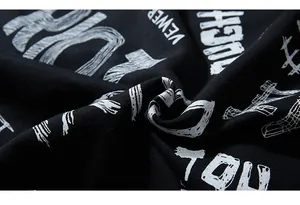 Macro view of street-style white graffiti letter prints on premium black cotton fabric