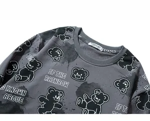 Detail of grey sweatshirt showing bear graffiti prints and ribbed crew neck design