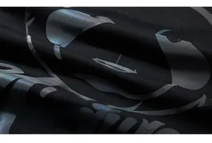 Détail macro de l'imprimé holographique réfléchissant sur tissu en maille noire premium