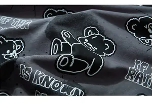 Detailed macro view of gray knitted cotton fabric with a stylized bear street print