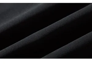Macro close-up of premium black knit cotton fabric texture showing detailed fiber weave