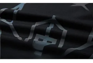Macro detail of black oversized hoodie fabric with gray reflective geometric pattern print