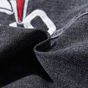 Close-up of heavy-duty charcoal denim vest featuring intricate red and white embroidery