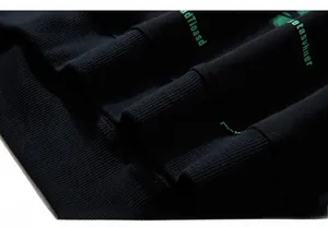 Detailed macro view of the ribbed cuff featuring a green letter print on black fabric