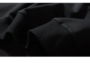 Detailed macro view of the ribbed cuffs and fine double-needle stitching on black sweatshirt