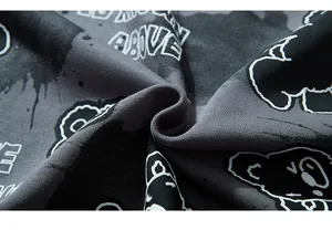 Close-up of grey ribbed knit fabric featuring a black cartoon bear and ABOVE lettering