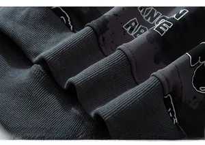 Macro detail of ribbed cuff and graphic print on oversized dark grey streetwear hoodie