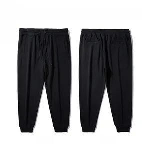 Detail view of black drawstring joggers showing front and back elastic cuff design