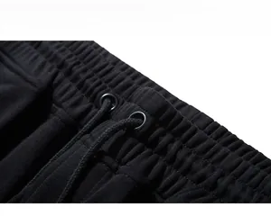 Detail view of black sweatpants waistband showing knit fabric and drawstring design
