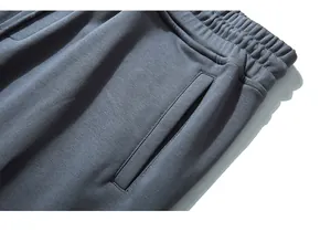 Detail of the elastic waistband and side pockets on dark gray knit sweatpants for men