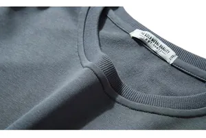 Close-up of the ribbed crew neck collar and high-quality knitted fabric of the gray-blue sweatshirt