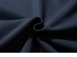 Macro view of navy blue high-quality knit fabric showing dense cotton texture and softness
