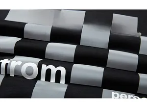 Close-up of black and grey checkerboard fabric with high-quality white slogan print