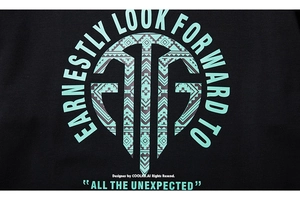 Détail de l'imprimé tribal géométrique bleu sarcelle et du texte sur T-shirt noir