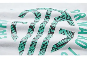 Détail de l'imprimé circulaire vert menthe sur le t-shirt blanc en coton à manches longues