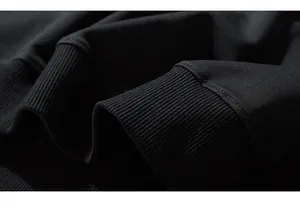 Close-up macro of premium black cotton ribbed cuffs on oversized men's fashion sweatshirt