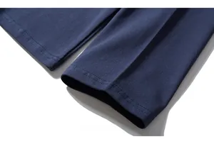 Dettaglio macro del polsino in maglia blu navy con cuciture precise a doppio ago