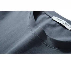 Detail of grey-blue crew neck knit T-shirt collar with size label and fine stitching