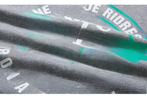 Macro detail of vintage green eagle print on premium grey cotton textured t-shirt fabric
